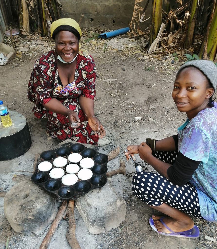 Two women cooking Massa over a fire